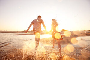 happy couple running on the beach