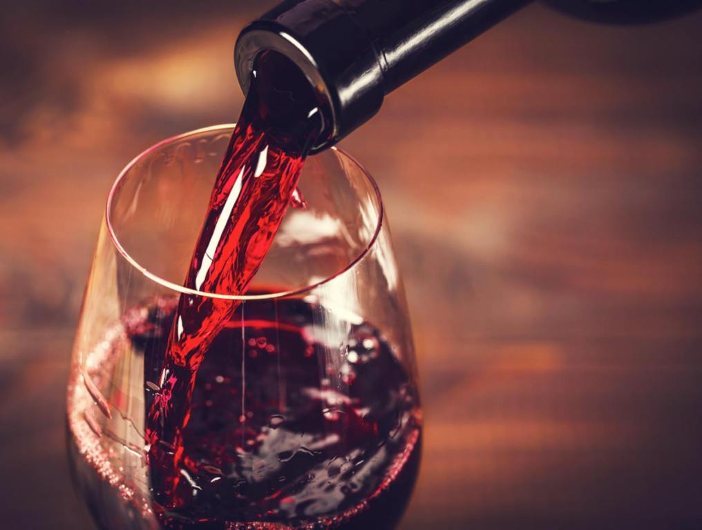 Pouring red wine into the glass against wooden background New Florida Law Will Allow You To Drink A Gallon Of Wine